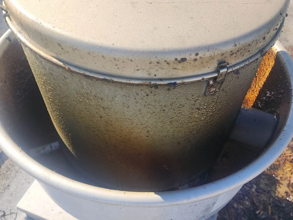 Rooftop kitchen exhaust fan with its housing and curb caked in grease, before cleaning